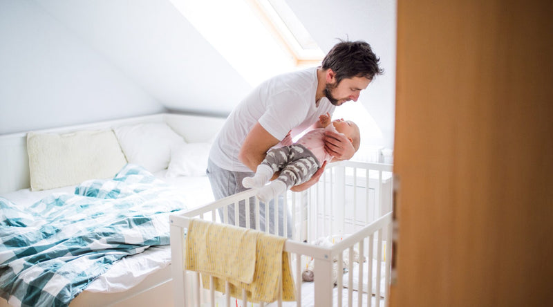 dad putting baby to bed