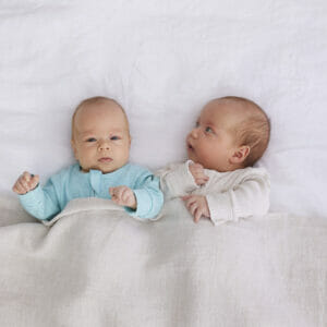 twin babies laying in bed