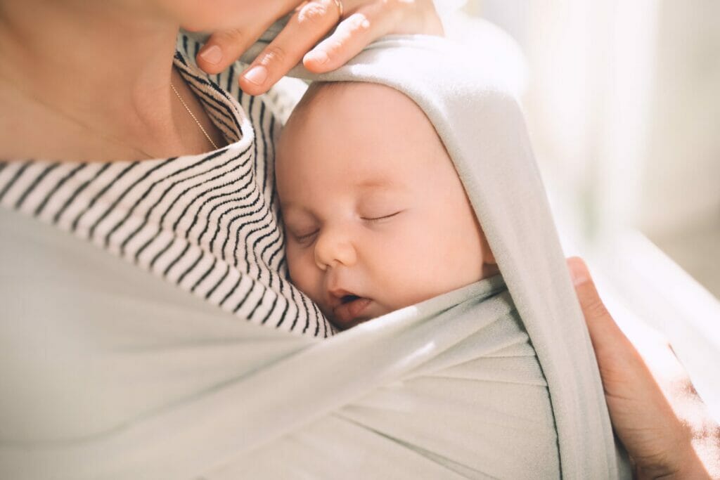mom holding baby in wrap